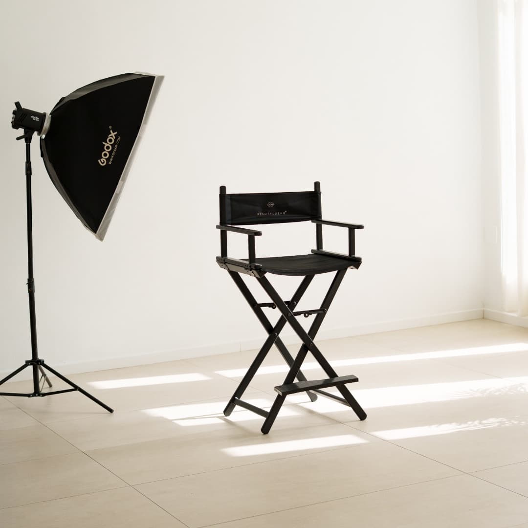 Foco Godox con softbox y silla de maquillaje sobre el fondo blanco del estudio